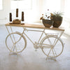 Another view of Kalalou Introducing the Rustic White Repurposed Bicycle Display Shelf! This one-of-a-kind piece is sure to turn heads and draw attention in any setting. It's perfect for retail display, trade shows, or even as a unique focal point in your office or home. (SKU# tb1). This table is available in Coffee Table Mart now.